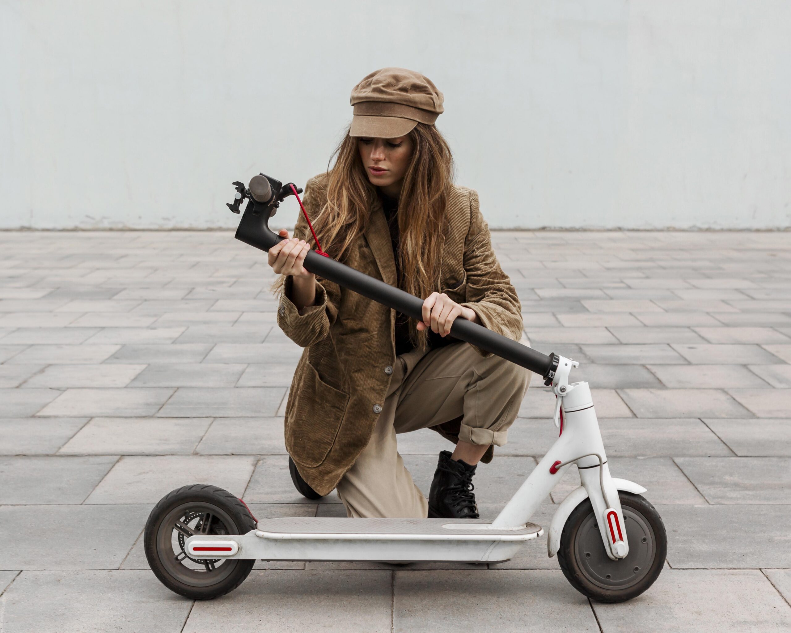 young woman holding her electric scooter